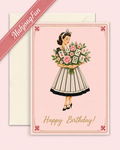 A retro-style birthday greeting card and envelope set. The card features an illustration of a woman in a black and white striped dress holding a bouquet of playing cards and flowers, with 'Happy Birthday!' written in gold script at the bottom.