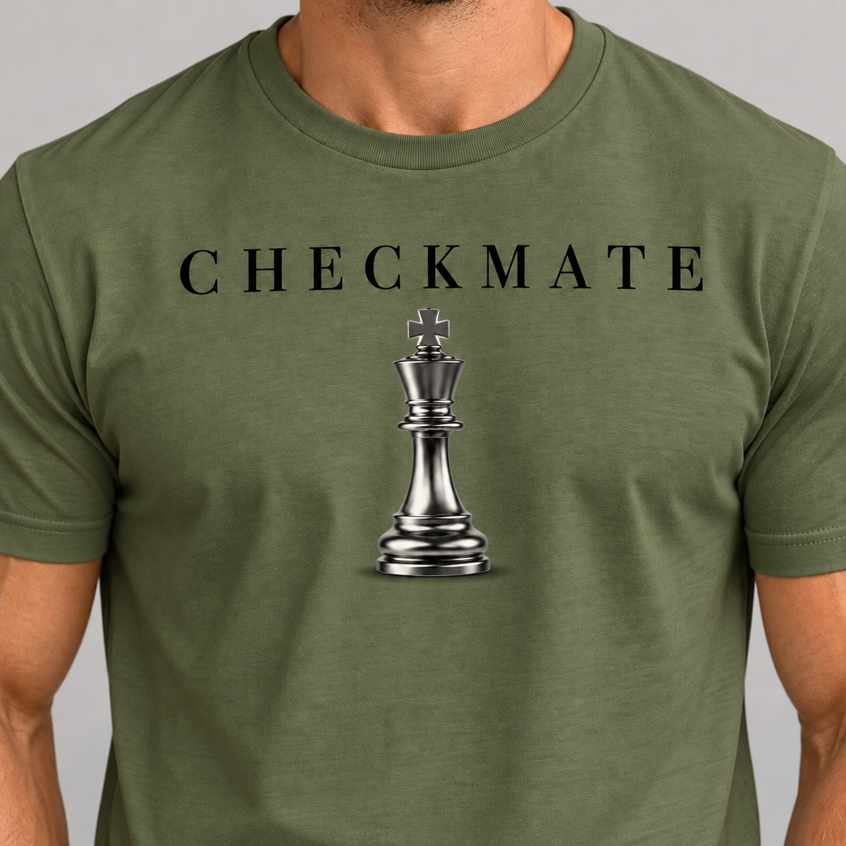 An olive green crewneck t-shirt worn by a model, featuring a black 'CHECKMATE' text graphic and a metallic silver chess king on the chest.