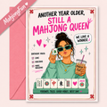 A pink and white Mahjong-themed greeting card with an illustrated woman holding mahjong tiles, shown with a pink envelope on a light pink background. The card reads 'ANOTHER YEAR OLDER, STILL A MAHJONG QUEEN' and includes a birthday mood checklist.