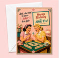 A retro-style happy birthday card with a white envelope, featuring a vintage illustration of two women from the fifties playing mahjong. The card reads 'And..she tried to use a joker in a pair”