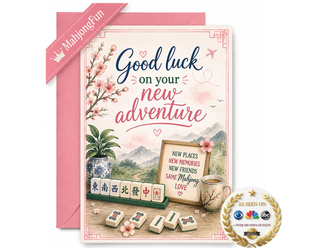 A pink and white 'Good luck on your new adventure' greeting card with a matching pink envelope. The card features Chinese-themed illustrations including mahjong tiles, a potted plant, a cup of tea, and a scenic mountain background.