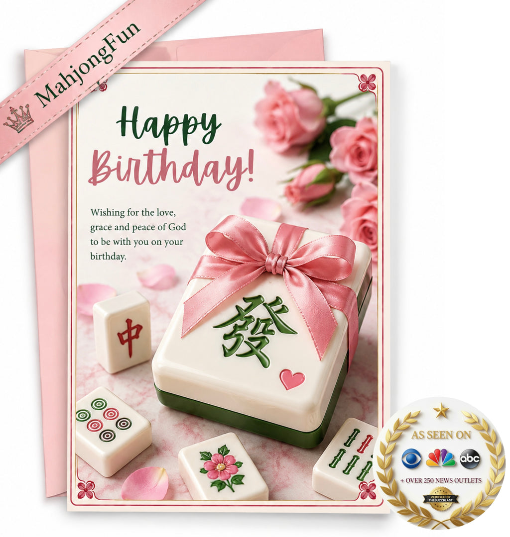 A pink and white Happy Birthday greeting card featuring a mahjong-themed design with a gift box wrapped in a pink ribbon, scattered mahjong tiles, and pink roses. A pink ribbon banner reads 'MahjongFun', and a gold 'As Seen On' badge is in the bottom right corner.
