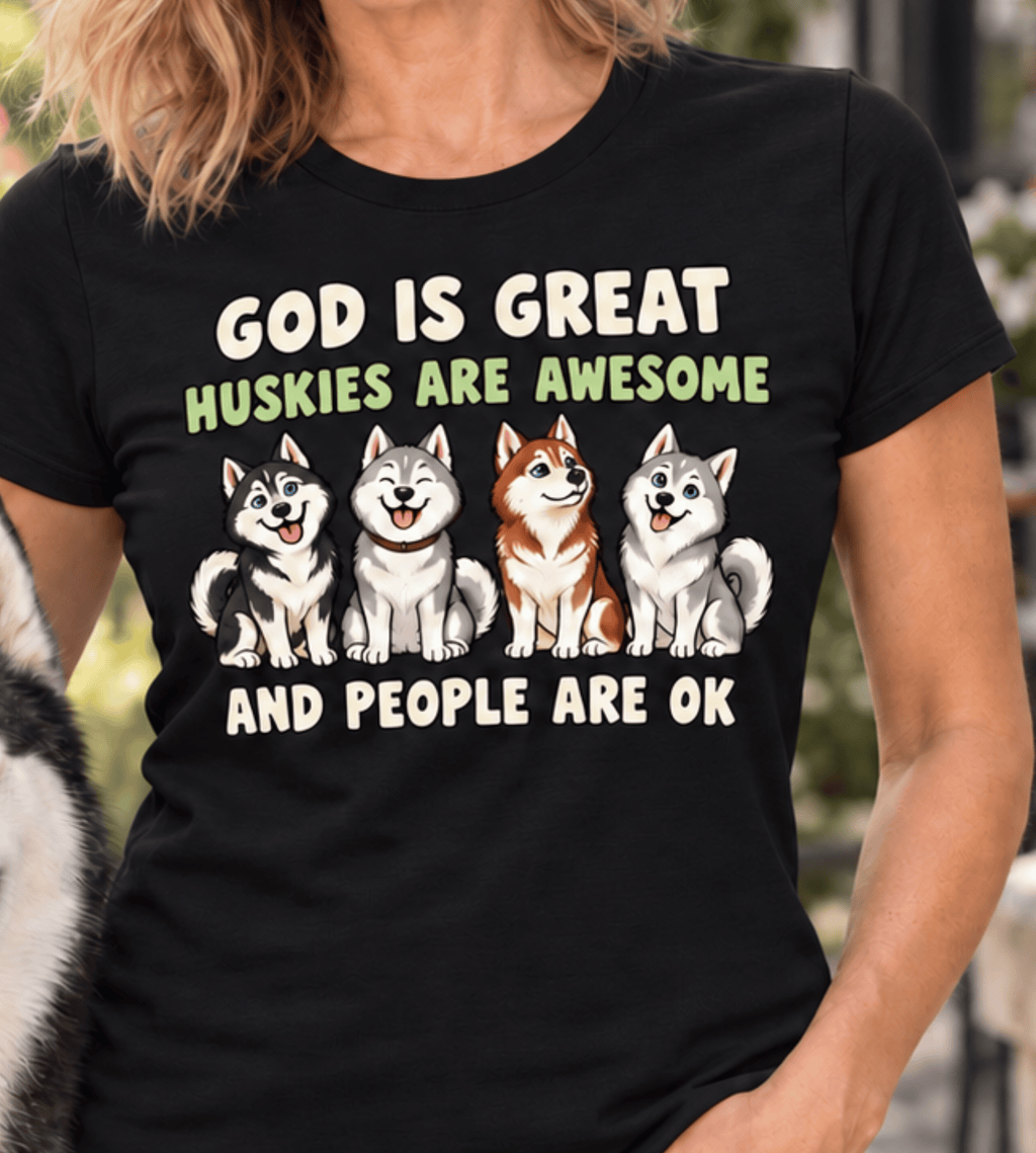 A woman wearing a black graphic t-shirt with the text 'GOD IS GREAT HUSKIES ARE AWESOME AND PEOPLE ARE OK' and an illustration of four husky dogs.